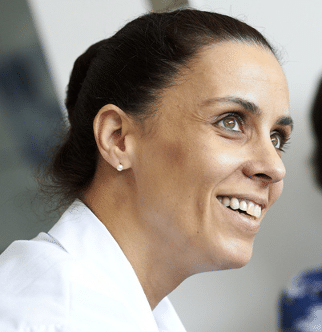 A head shot showing the profile of Inés Colmega looking up at another person out of frame.
